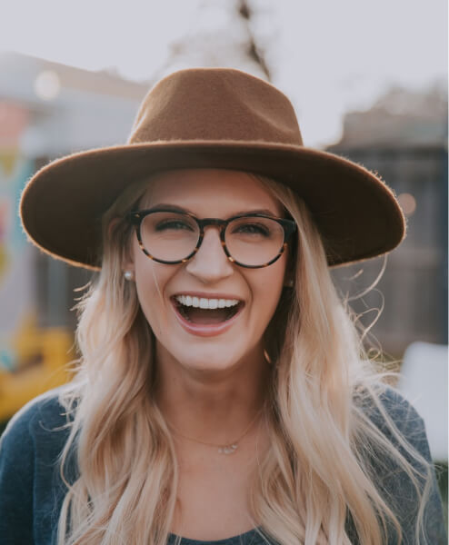 Portrait of Eleanor Pena, a Medical Assistant, smiling and wearing a hat and glasses.